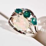 Sterling silver ring set with a large Ethiopian Opal and three small emeralds.