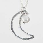This is a sterling silver moon shaped pendent with a fresh water pearl.